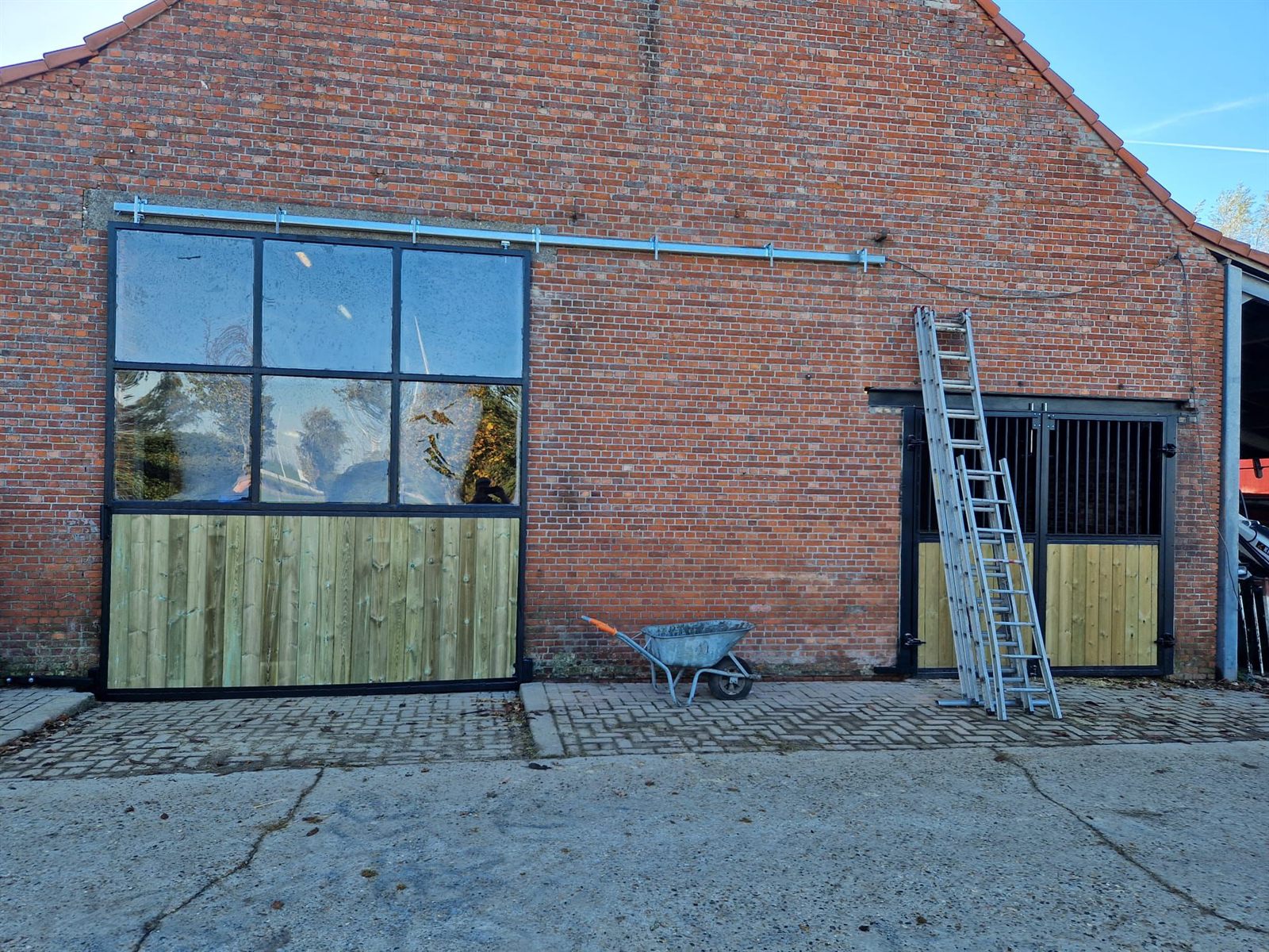Grote metalen staldeur en dubbele poort met houten bekleding