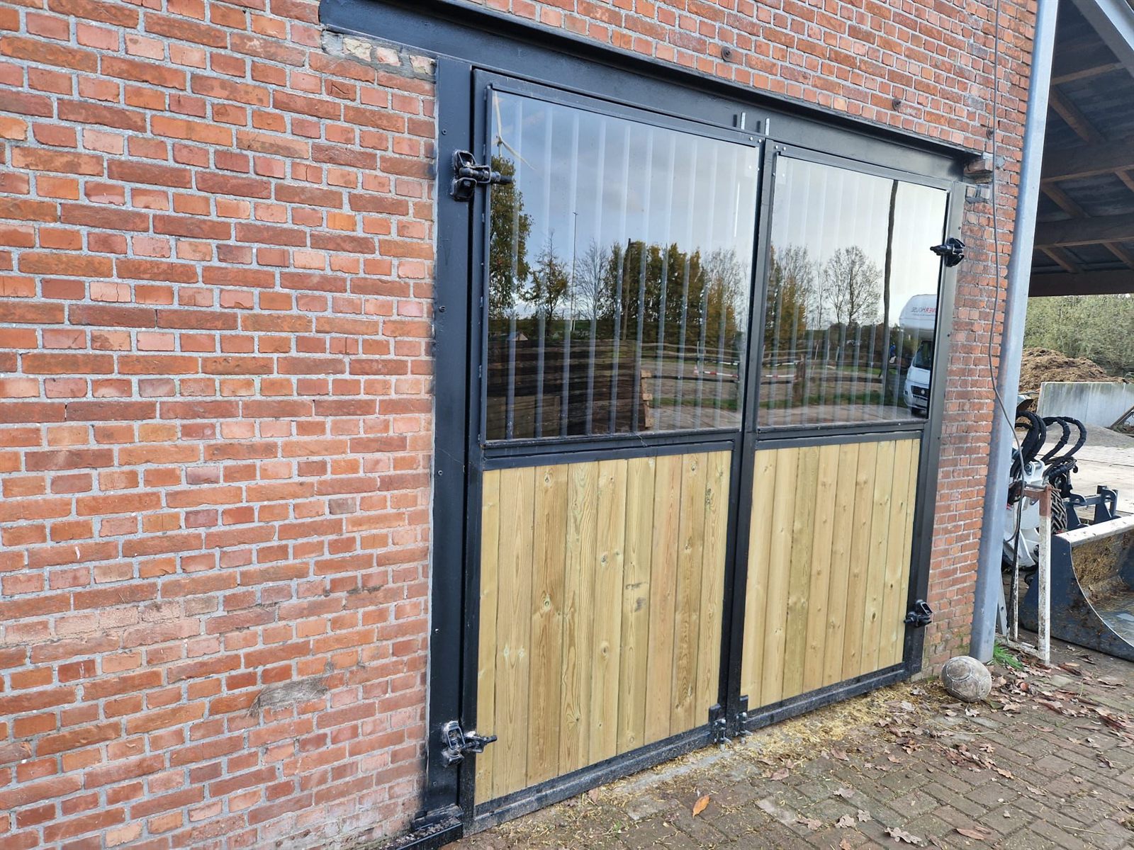 Dubbele metalen staldeur met glas en houten panelen